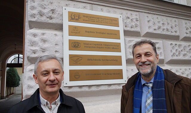 István Durkó und János Papp vor Akademie und Zentrale der Baptisten 